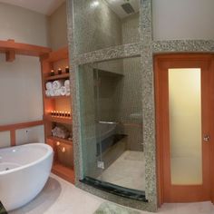 a bath room with a large white tub and a walk in shower next to a sink