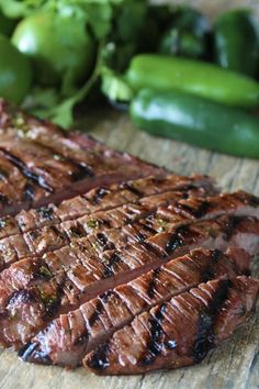 the steak has been grilled and is ready to be served on the table with green peppers