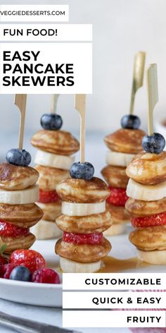 mini pancakes with blueberries and strawberries on them are arranged on a white plate