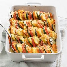 a casserole dish with zucchini, tomatoes and other veggies