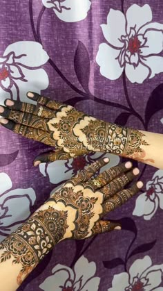 two hands with henna tattoos on them