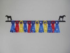 a row of colorful ribbons hanging on a wall next to a black horse figurine