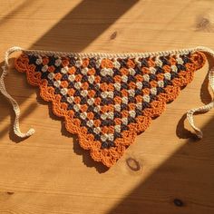 a crocheted triangle is sitting on the floor