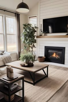 a living room with a couch, coffee table and television on the fireplace mantel