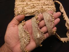 a person holding some gold chains in their hand