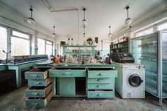 an old kitchen with lots of drawers and appliances in the center, including a washer and dryer