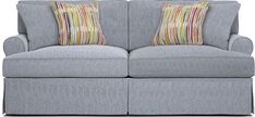 a gray couch with two pillows on it's back and the arms facing each other