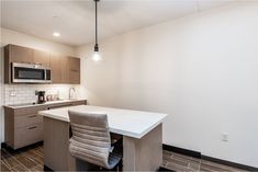 a kitchen with a white counter top next to a microwave oven