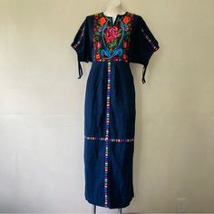 Great Pre-Owned Condition, No Defects Other Than Some Minor Signs Of Use. Beautiful Vintage Circa 1970s Guatemalan Huipil-Style Maxi Folk Dress, In A Dark Indigo Blue With Colorful Woven Designs. It Has A Pull-On Fit With No Closures, And A Low Waist With An Attached Tie - When You Tie It At The Back Of Your Natural Waist, It Cinches Up The Bodice For A Blouson Effect. It Has Half-Length Dolman Sleeves That Cinch, A Notched Neckline That Lies Open, And Pleating On The Front Of The Skirt. Mannequ Blue Fitted Folk Dress, Spring Embroidered Blue Maxi Dress, Blue Embroidered Dress For Festival, Blue Folk Style Dress With Intricate Embroidery, Blue Folk Dress With Intricate Embroidery, Blue Folk Embroidered Dress With Intricate Embroidery, Blue Cotton Folk Dress, Blue Cotton Maxi Dress With Floral Embroidery, Folk Style Embroidered Fitted Maxi Dress