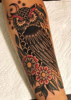 an owl and flowers tattoo on the arm