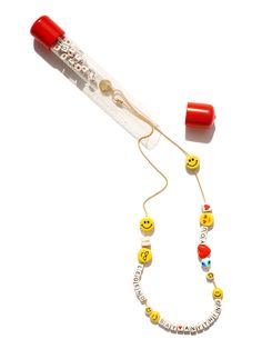 a necklace with smiley faces and beads is shown in the shape of a toothbrush