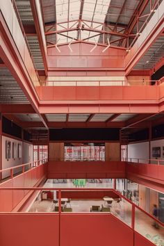 the inside of an empty building with lots of windows and red walls on each floor