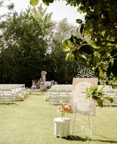 an outdoor ceremony with white chairs and flowers