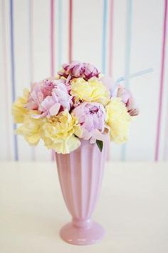 a pink vase filled with yellow and pink flowers