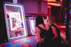 two women are sitting in front of a television