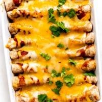 chicken enchilada casserole with cheese and cilantro on top