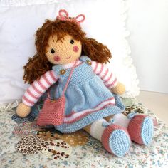 a knitted doll is sitting on a bed