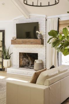 a living room with a couch, fireplace and tv on the wall in it's corner