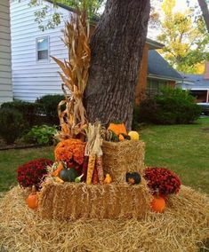 a hay bale with pumpkins and corn on it