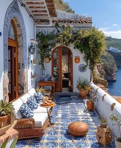 an outdoor living area with blue and white tiles on the floor, potted plants in pots