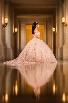 a woman in a ball gown standing on the floor