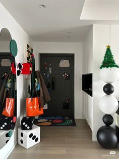 a hallway with black and white decorations and balloons on the wall, including a christmas tree