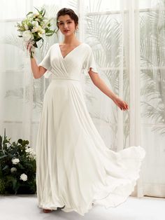 a woman in a white dress holding a bouquet of flowers