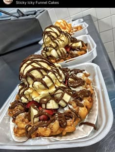 two trays filled with waffles covered in ice cream and toppings on top of them