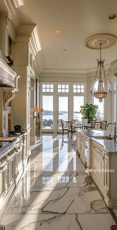 a large kitchen with marble counter tops and white cabinets