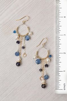 Experience the beauty and craftsmanship of the Seaside Collection with these gorgeous handmade earrings. Mixed Metal (lead and nickel free) Kyanite, Iolite, Pearl 3", with gold filled ear wires We hand select our natural materials, thus there may be slight variations in color and/or size that will not detract from the overall aesthetic Our unique handcrafted designer jewelry for women is made in America, with each design created individually in our personal design studio in Floyd VA USA Silver Gold Earrings, Silver Gold Necklace, Pearl Jewelry Design, Fancy Beads, Handcrafted Earrings, Beaded Jewelry Patterns, Jewelry Patterns, Diy Earrings, Pretty Jewellery