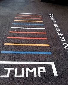 an empty parking lot with the word jump painted on it and lines drawn in different colors