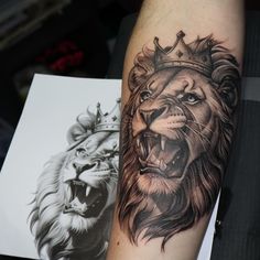 a lion with a crown tattoo on his arm