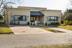 a house with a driveway in front of it and two bikes parked on the other side