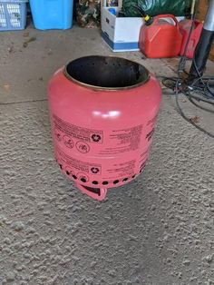 a pink fire hydrant sitting on top of a cement floor next to other items