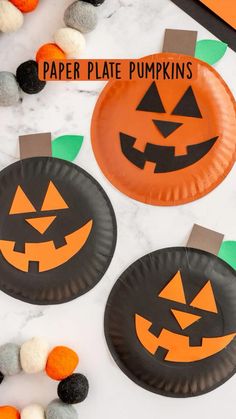 paper plate pumpkins on a table with pom poms