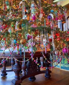 a christmas tree with ornaments hanging from it's branches and lights on the top