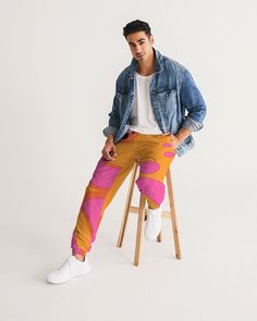 Our Men's Track Pants are both lightweight and versatile and the colorful lava lamp inspired print will blow your mind. Its water-resistant fabric keeps you dry and comfortable so you can get active with ease and its relaxed fit makes it great street-worthy style. Zipper pockets to keep your stash safe! + Lightweight, water-resistant fabric + Zip pockets + Elastic waistband, ankle cuffs + Fully lined, mesh lining + Printed, cut, and handmade Fit + Relaxed fit + Sits at hip + Inseam, size Medium: 30" + Model is 6'2 wearing size Medium + Measurements vary, +/- 0.5" per size + Model's inseam is 32" Material & Care + Machine wash cold, tumble dry low + 100% Polyester + Fabric weight: 2.21 oz/yd² (75g/m²) + Imported SHIPPING:  Your items are handmade on-demand  100% Recycled Packaging & Ethical Retro Pink Pants With Pockets, Retro Orange Bottoms With Pockets, Retro Orange Trousers, Lamp Inspired, Fashion 70s, Get Active, 70s Retro, Ankle Cuffs, Water Resistant Fabric