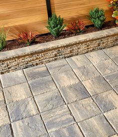 an outdoor patio with stone pavers and plants