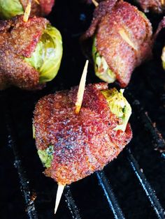 some food is cooking on a grill with toothpicks sticking out of the meat