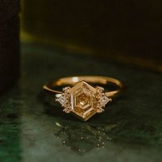 a yellow diamond ring sitting on top of a table