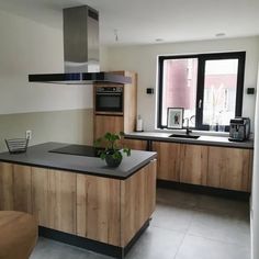 a modern kitchen with wooden cabinets and black counter tops is pictured in this image from the front view