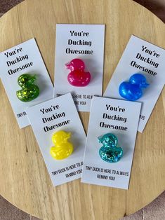 three different colored rubber ducks sitting on top of a wooden table