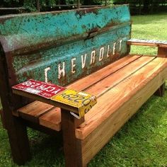 the bench is made out of wood and has graffiti painted on it's back