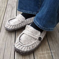 someone is wearing crocheted slippers with buttons on the bottom and one foot