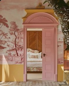 an open door leading to a bedroom with a pink bed and wall mural behind it