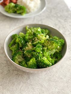 two bowls filled with broccoli on top of a table