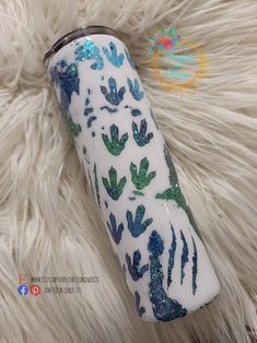 a white and blue vase sitting on top of a fur covered floor