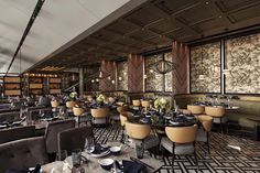 a restaurant with tables and chairs covered in black and gold cloths, along with wallpapered walls