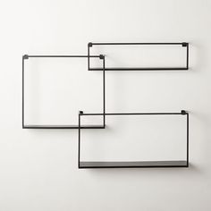 three black shelves on the wall, one with two open ones and one without them