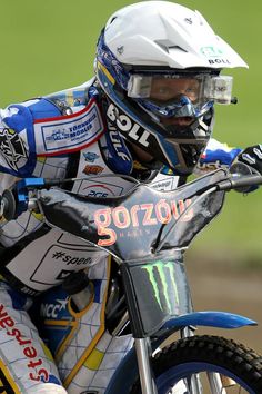 a man riding on the back of a dirt bike in a race suit and helmet